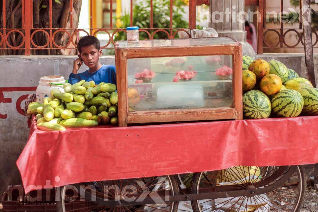 A little boy sells cucumber and water melons on the way to Laxman Jhula at Rishikesh