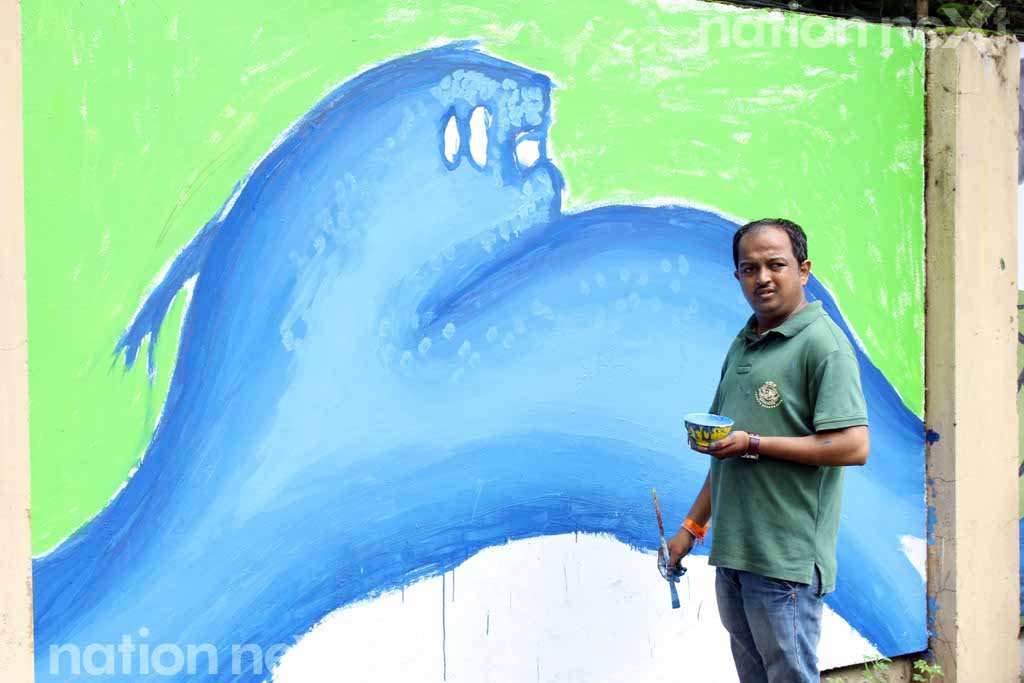 Roshan Dhote poses in front of his painting at Graffiti Wall, a wall designing programme organized at IIID Design Yatra. He wanted to raise the issue of conservation of wildlife through his painting