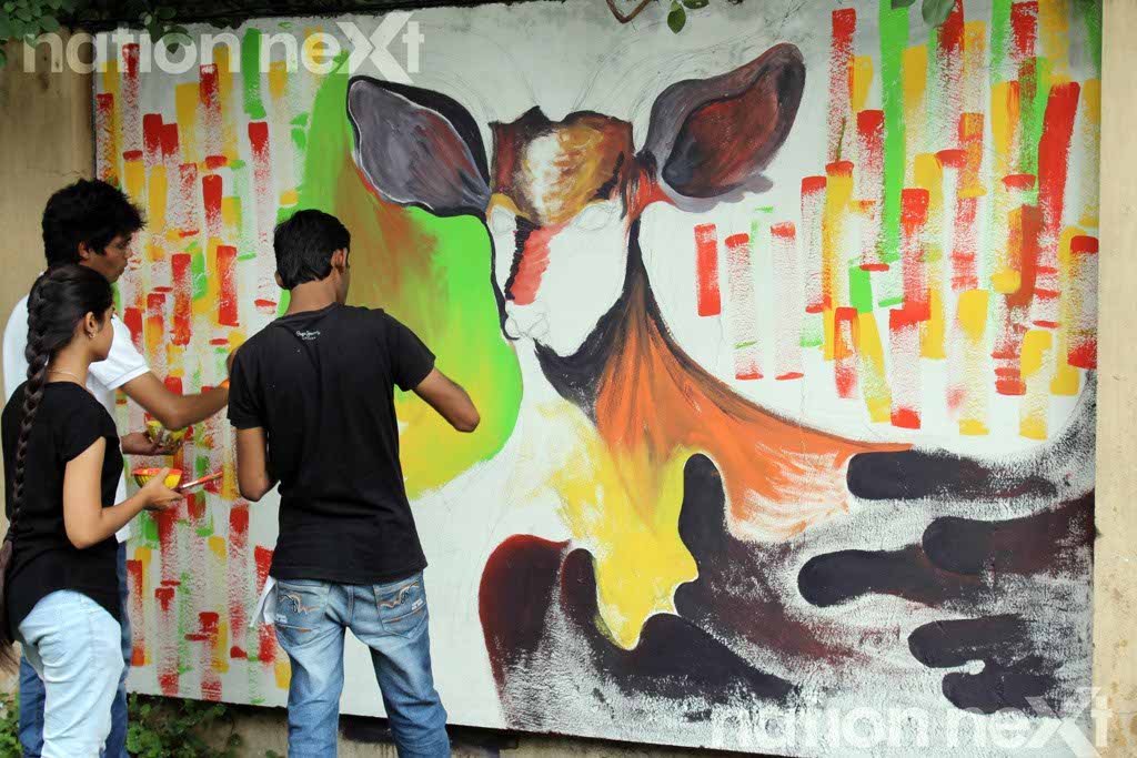 Sakshi Rathi, Aayush Beherkhede and Gaurav Kosamkar try to creatively make a Deer in their painting at Graffiti Wall, a wall designing programme organized at IIID Design Yatra