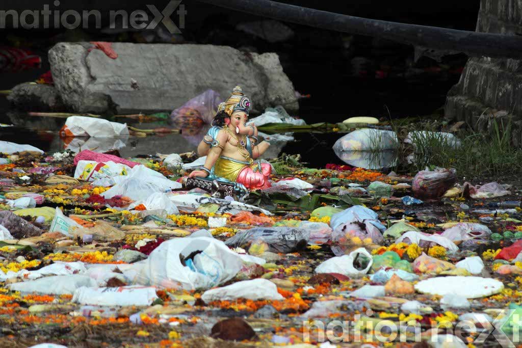 SPARE ME PLEASE! A Lord Ganesha idol with broken hands, lying on a pile of garbage at Futala Lake, Nagpur